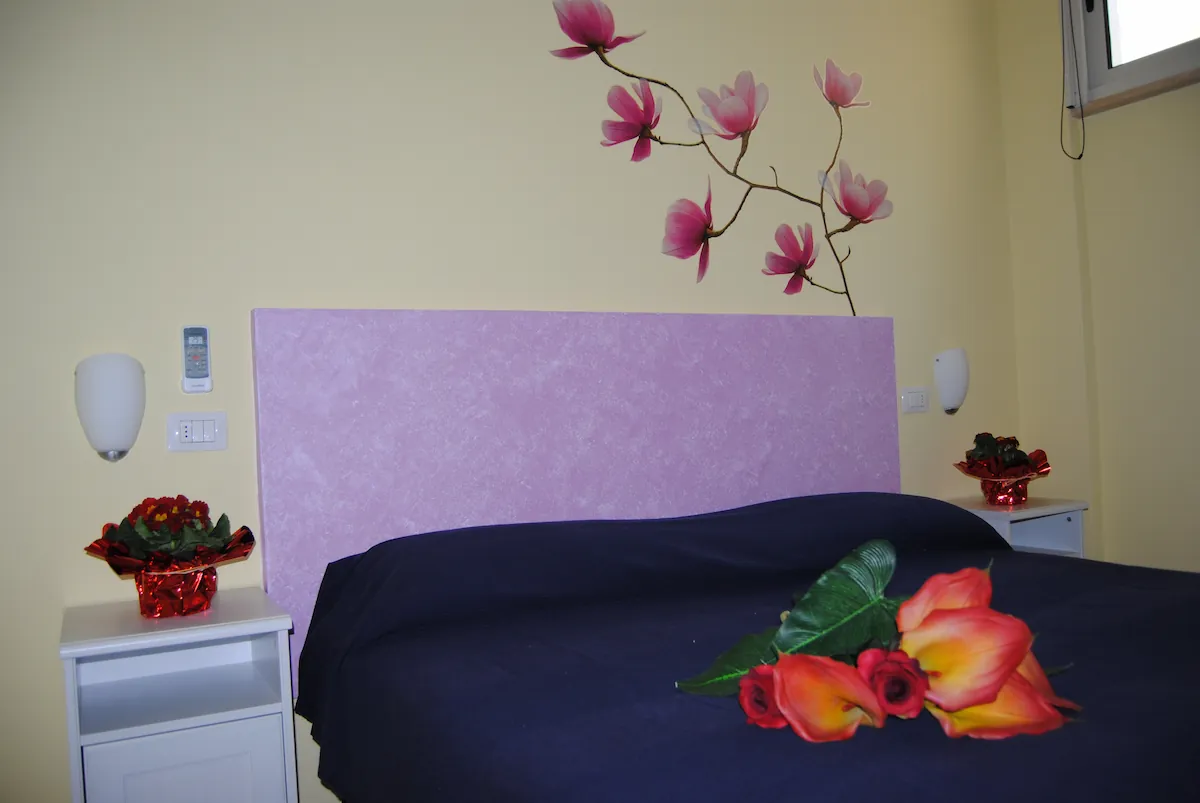 Camera matrimoniale accogliente con decorazioni floreali - B&B Sunshine Otranto